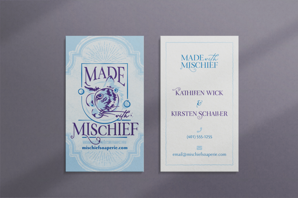 a mockup image showing both sides of the Made with Mischief business card. the front has the logo and website on a distressed light blue background. the back has the text only logo in cobalt blue with blue and purple text and a squiggly light blue border on a white background. the image has a lavender-gray background with faint abstract shadows