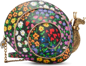 A figural handbag where the main compartment is an irregular, circular pouch made of colorful floral leather divided by a spiral of rose-gold glitter trim. A big, antique brass snail head emerges from the right end of the "shell".